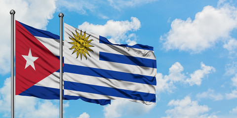 Cuba and Uruguay flag waving in the wind against white cloudy blue sky together. Diplomacy concept, international relations.