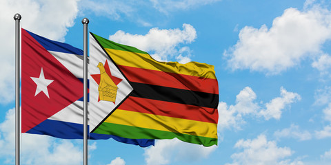 Cuba and Zimbabwe flag waving in the wind against white cloudy blue sky together. Diplomacy concept, international relations.