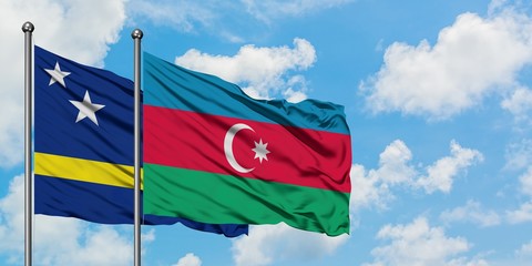 Curacao and Azerbaijan flag waving in the wind against white cloudy blue sky together. Diplomacy...