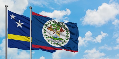 Curacao and Belize flag waving in the wind against white cloudy blue sky together. Diplomacy concept, international relations.