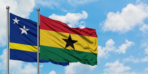 Curacao and Ghana flag waving in the wind against white cloudy blue sky together. Diplomacy concept, international relations.
