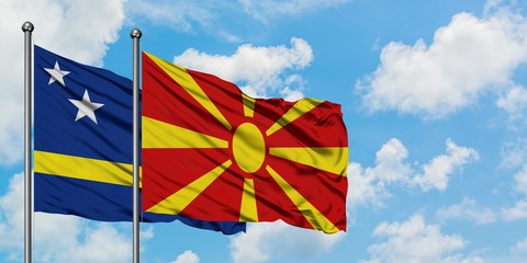 Curacao and Macedonia flag waving in the wind against white cloudy blue sky together. Diplomacy concept, international relations.