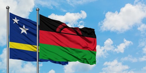 Curacao and Malawi flag waving in the wind against white cloudy blue sky together. Diplomacy concept, international relations.
