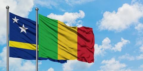 Curacao and Mali flag waving in the wind against white cloudy blue sky together. Diplomacy concept, international relations.