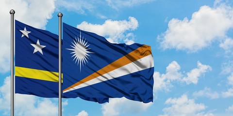 Curacao and Marshall Islands flag waving in the wind against white cloudy blue sky together. Diplomacy concept, international relations.