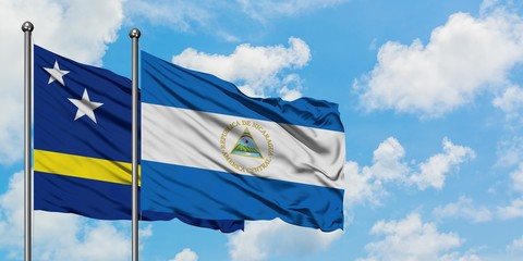 Curacao and Nicaragua flag waving in the wind against white cloudy blue sky together. Diplomacy concept, international relations.