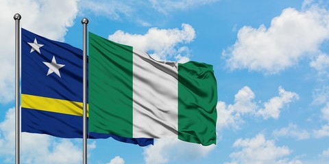 Curacao and Nigeria flag waving in the wind against white cloudy blue sky together. Diplomacy concept, international relations.