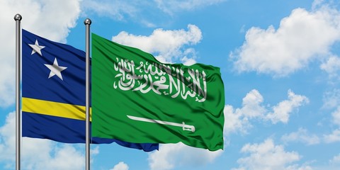 Curacao and Saudi Arabia flag waving in the wind against white cloudy blue sky together. Diplomacy concept, international relations.