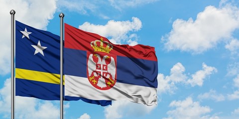 Curacao and Serbia flag waving in the wind against white cloudy blue sky together. Diplomacy concept, international relations.