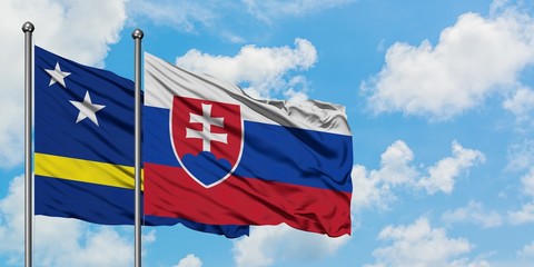 Curacao and Slovakia flag waving in the wind against white cloudy blue sky together. Diplomacy concept, international relations.