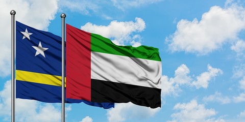 Curacao and United Arab Emirates flag waving in the wind against white cloudy blue sky together. Diplomacy concept, international relations.