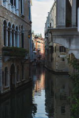 Fototapeta na wymiar View of the canals and buildings of Venice. Beautiful historic brick buildings on the narrow streets and canals of the ancient city. Warm autumn day, travel to Italy.