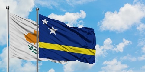 Cyprus and Curacao flag waving in the wind against white cloudy blue sky together. Diplomacy concept, international relations.