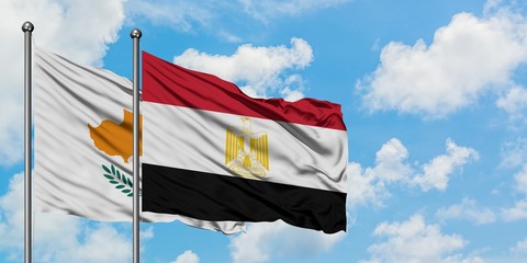 Cyprus and Egypt flag waving in the wind against white cloudy blue sky together. Diplomacy concept, international relations.