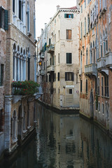 View of the canals and buildings of Venice. Beautiful historic brick buildings on the narrow streets and canals of the ancient city. Warm autumn day, travel to Italy.