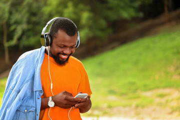 Handsome African-American man listening to music outdoors