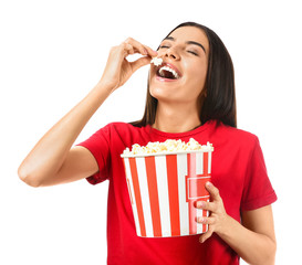 Young woman eating popcorn on white background