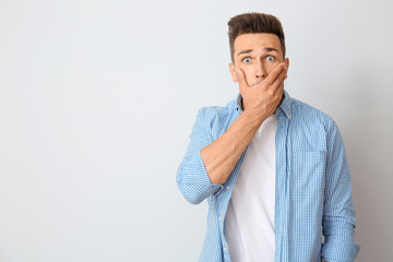 Surprised young man on light background