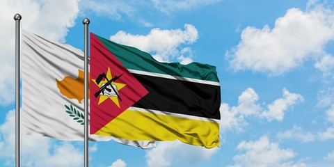 Cyprus and Mozambique flag waving in the wind against white cloudy blue sky together. Diplomacy...