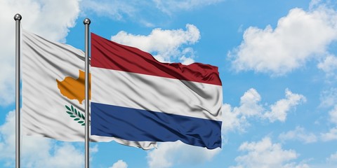 Cyprus and Netherlands flag waving in the wind against white cloudy blue sky together. Diplomacy concept, international relations.