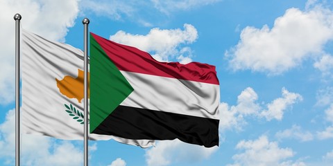 Cyprus and Sudan flag waving in the wind against white cloudy blue sky together. Diplomacy concept, international relations.