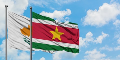 Cyprus and Suriname flag waving in the wind against white cloudy blue sky together. Diplomacy concept, international relations.