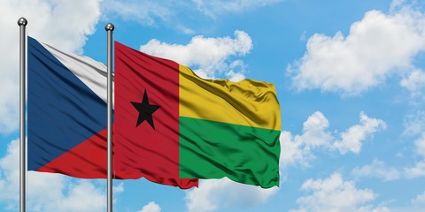 Czech Republic and Guinea Bissau flag waving in the wind against white cloudy blue sky together. Diplomacy concept, international relations.
