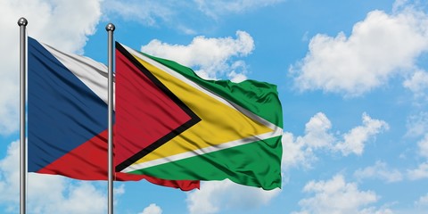 Czech Republic and Guyana flag waving in the wind against white cloudy blue sky together. Diplomacy concept, international relations.