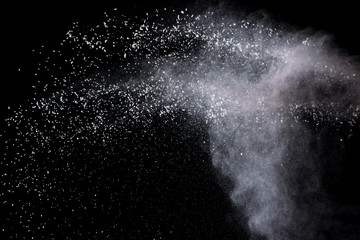 Freeze motion of white color powder exploding on dark background. 