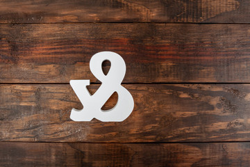 Carved ampersand symbol on wooden table - top view with copy space