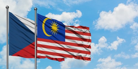 Czech Republic and Malaysia flag waving in the wind against white cloudy blue sky together. Diplomacy concept, international relations.