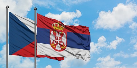 Czech Republic and Serbia flag waving in the wind against white cloudy blue sky together. Diplomacy concept, international relations.