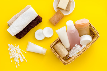 Bathroom cosmetics and hygiene products on yellow background top view