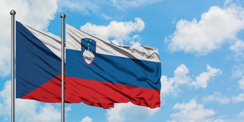 Czech Republic and Slovenia flag waving in the wind against white cloudy blue sky together. Diplomacy concept, international relations.