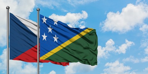 Czech Republic and Solomon Islands flag waving in the wind against white cloudy blue sky together....