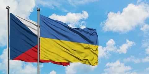 Czech Republic and Ukraine flag waving in the wind against white cloudy blue sky together. Diplomacy concept, international relations.