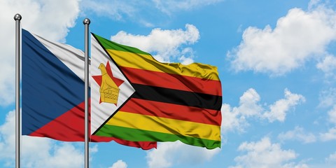 Czech Republic and Zimbabwe flag waving in the wind against white cloudy blue sky together. Diplomacy concept, international relations.
