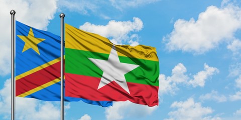 Congo and Myanmar flag waving in the wind against white cloudy blue sky together. Diplomacy...