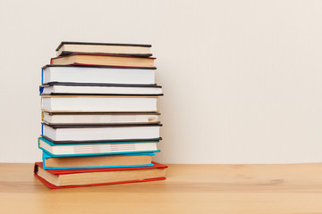Simple composition of many hardback books, raw of books on wooden table and light  background