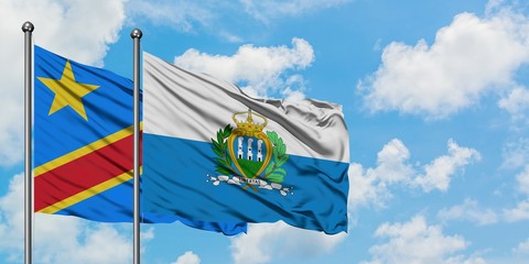 Congo and San Marino flag waving in the wind against white cloudy blue sky together. Diplomacy concept, international relations.
