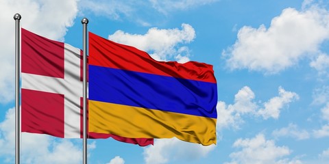 Denmark and Armenia flag waving in the wind against white cloudy blue sky together. Diplomacy concept, international relations.