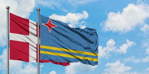 Denmark and Aruba flag waving in the wind against white cloudy blue sky together. Diplomacy concept, international relations.