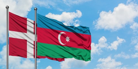 Denmark and Azerbaijan flag waving in the wind against white cloudy blue sky together. Diplomacy concept, international relations.