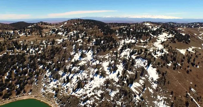 Aerial of snowy mountains with Argan trees in Atlas mountains in Morocco