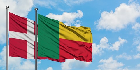 Denmark and Benin flag waving in the wind against white cloudy blue sky together. Diplomacy concept, international relations.