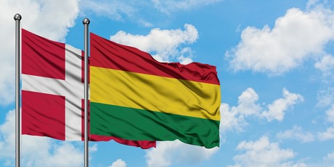 Denmark and Bolivia flag waving in the wind against white cloudy blue sky together. Diplomacy concept, international relations.