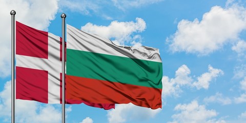 Denmark and Bulgaria flag waving in the wind against white cloudy blue sky together. Diplomacy concept, international relations.