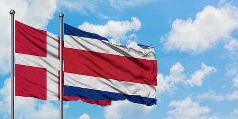 Denmark and Costa Rica flag waving in the wind against white cloudy blue sky together. Diplomacy concept, international relations.