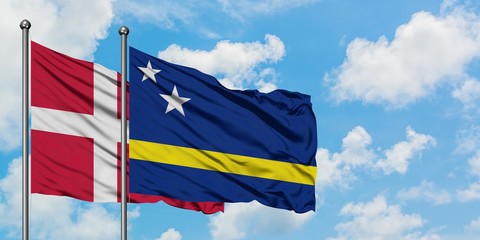 Denmark and Curacao flag waving in the wind against white cloudy blue sky together. Diplomacy concept, international relations.