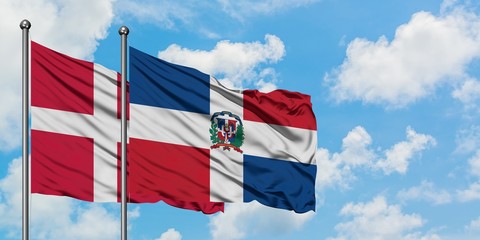 Denmark and Dominican Republic flag waving in the wind against white cloudy blue sky together. Diplomacy concept, international relations.